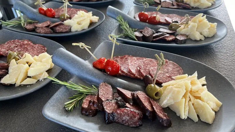 Elegant angerichtete italienische Platten mit Salami, Parmesan, Oliven und Tomaten.