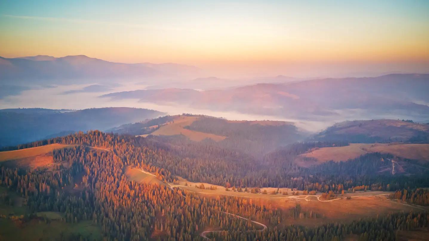 Herbstlich gedeckter Tisch mit Kürbis, Obst und Käse auf einer Sonnenterrasse mit Blick auf die Glarner Alpen im goldenen Oktober