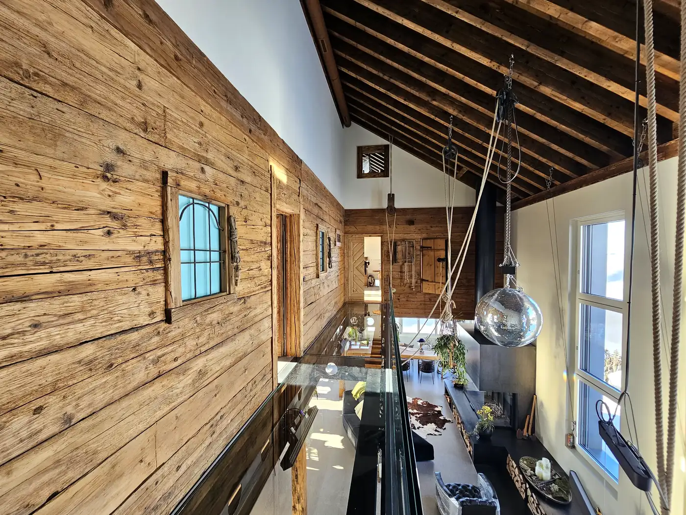 Eventlokal mieten auf der Fronalp – Altholz-Innenraum des Stockhus mit Glasboden und Bergblick
